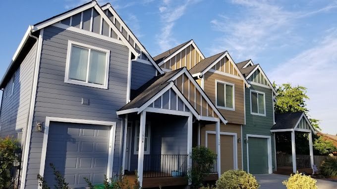 A row of houses with a blue sky in the background.