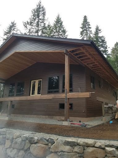 A house with a large porch is surrounded by trees