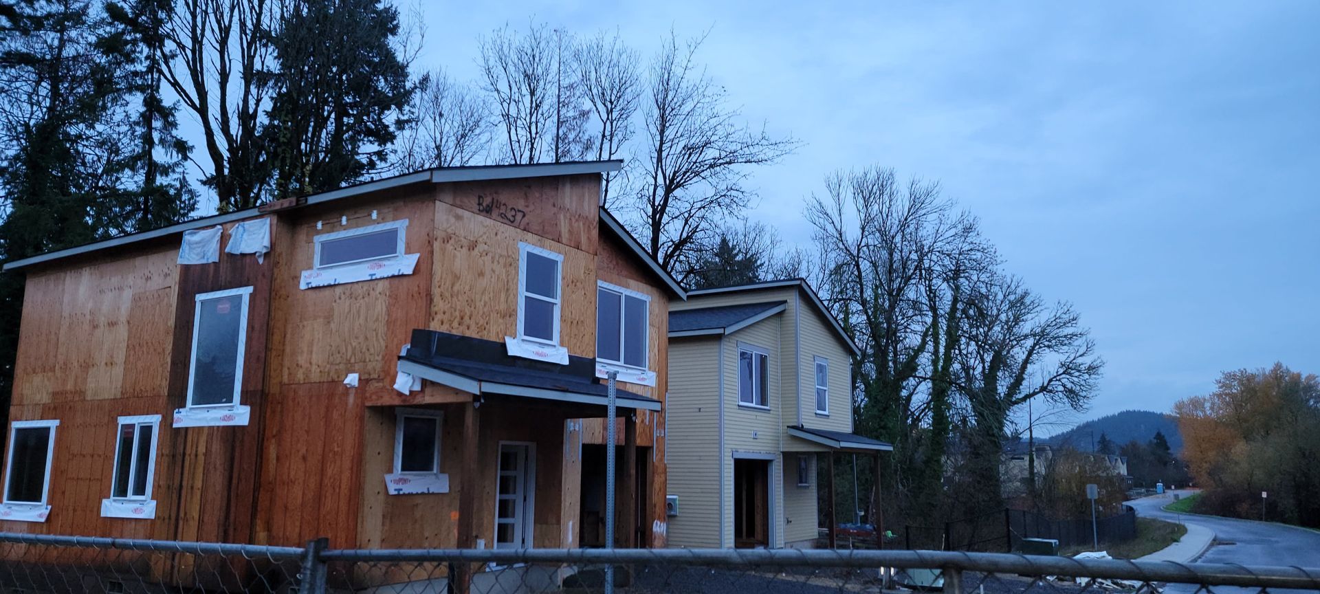 A row of houses are being built in a residential area.