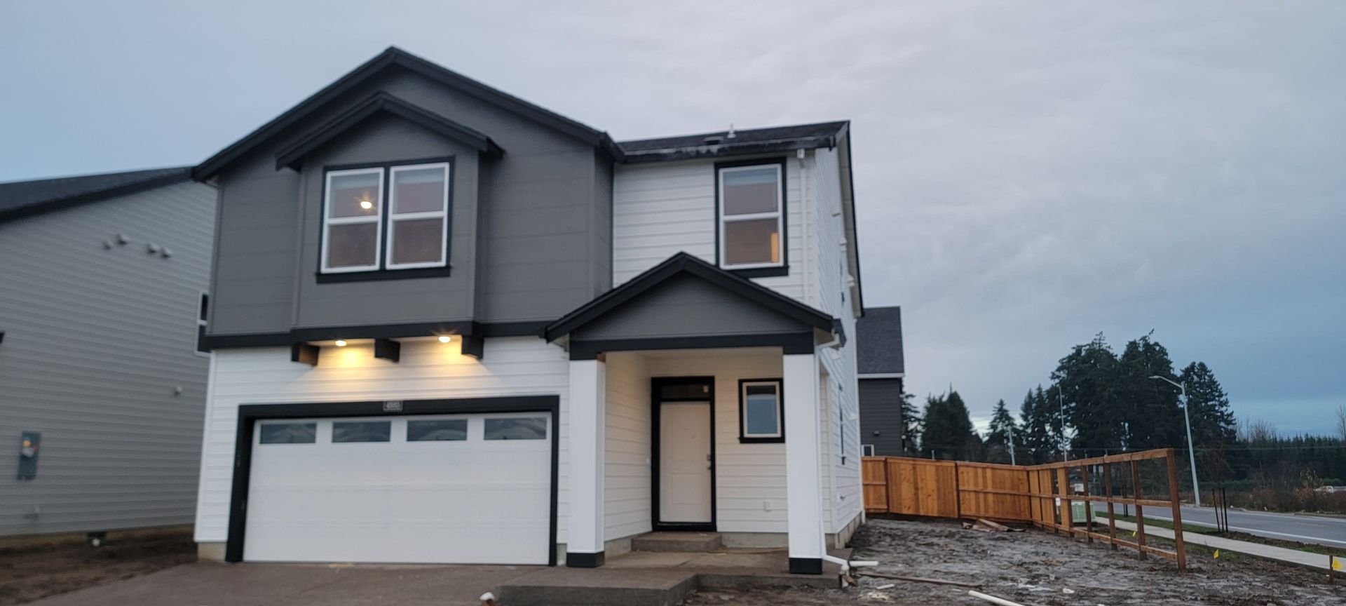 A gray and white house with a garage and a porch.
