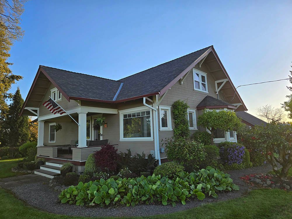 A large house with a porch and a flag on it.