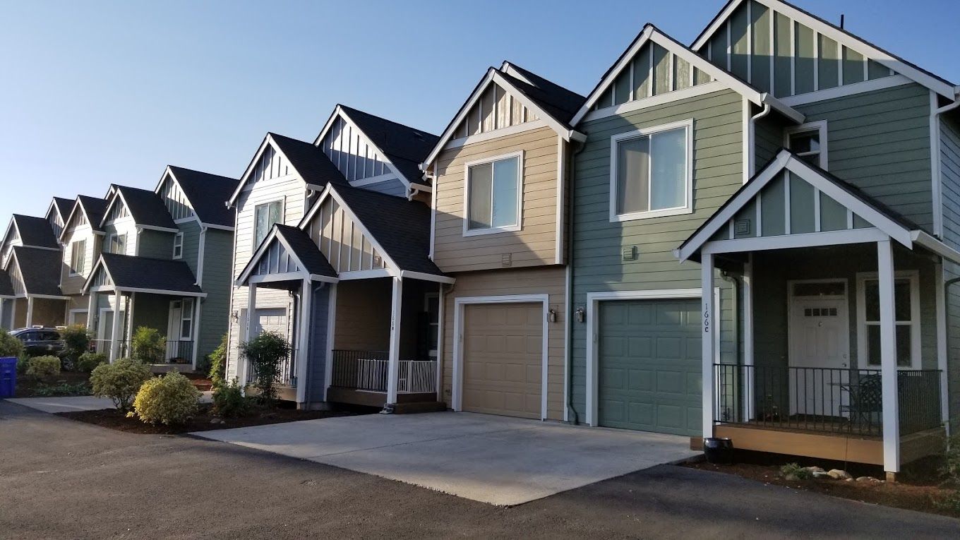 A row of houses with a blue sky in the background