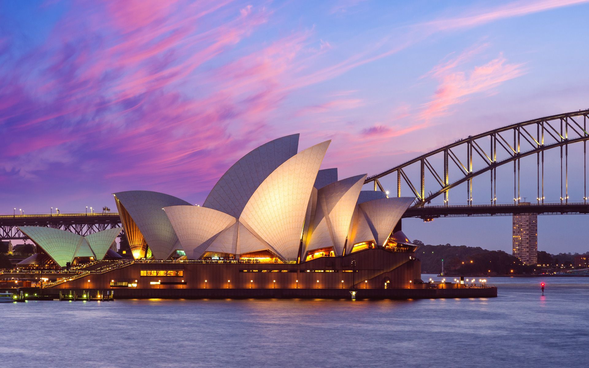 The opera house in sydney is lit up at night