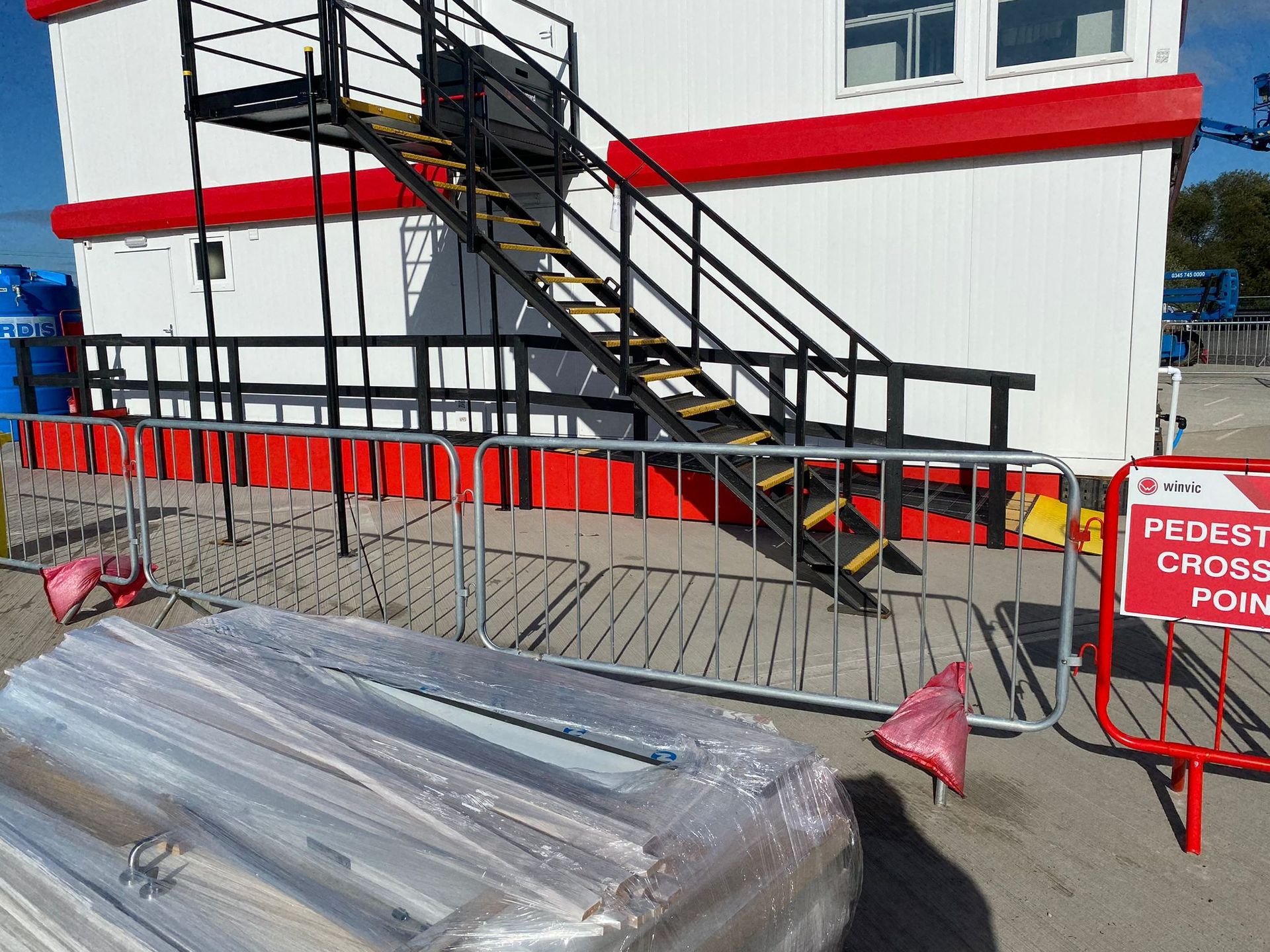 Staircase with a handrail ascending to the top. Shadows are cast along the wall.