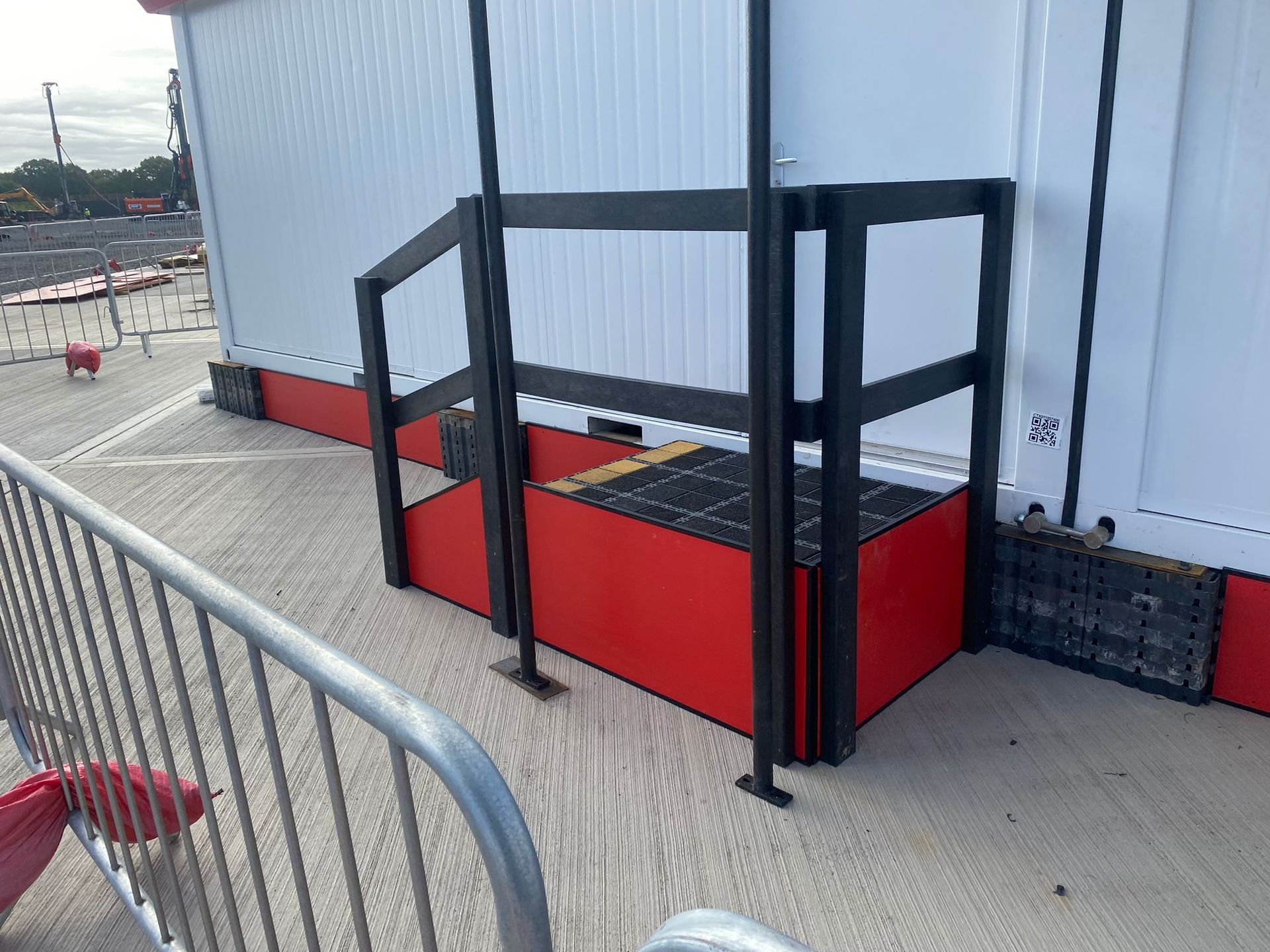 Silhouette of a person walking toward an escalator in a dark, modern building.