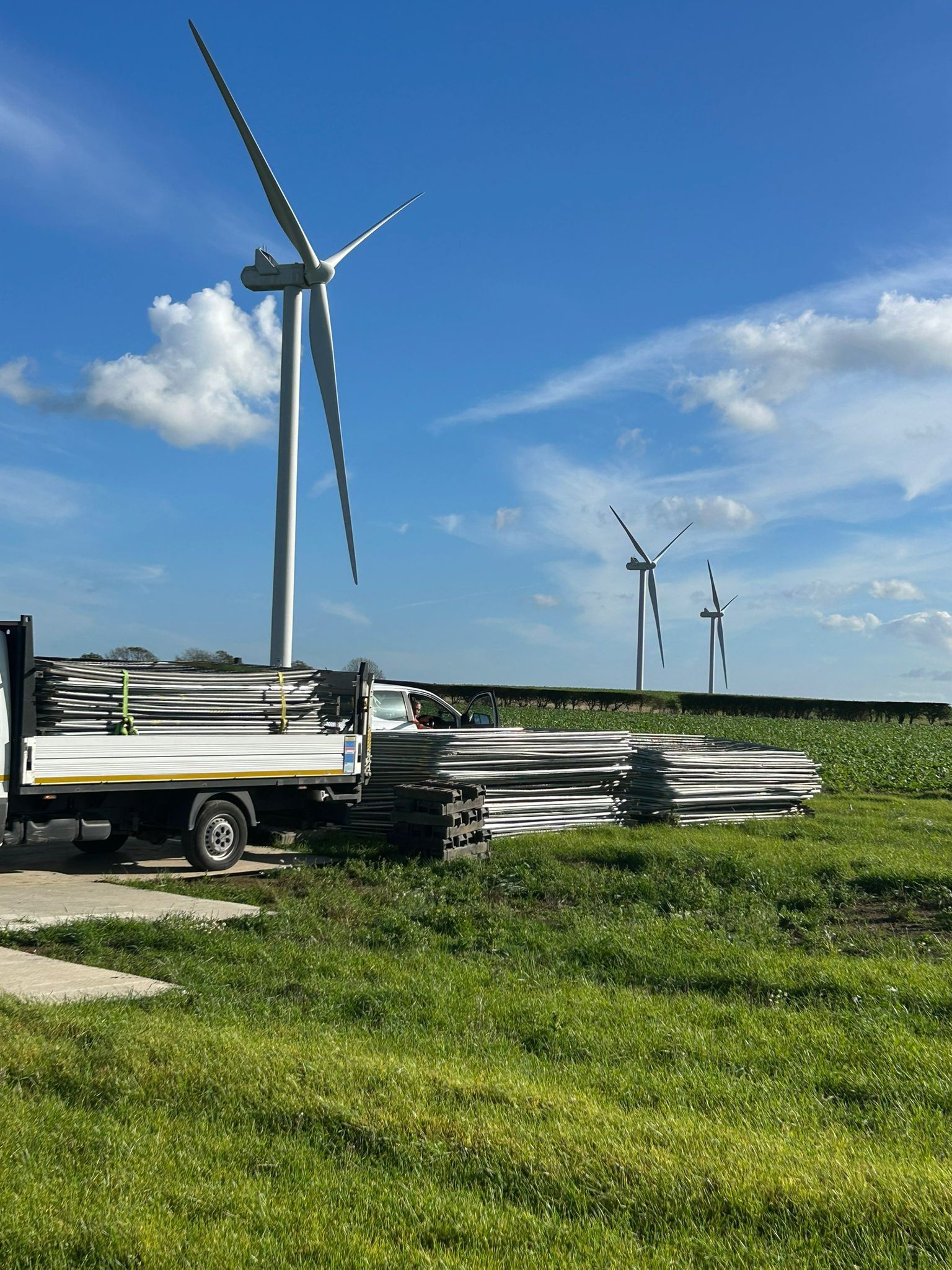 Green privacy screen fence in front of a house under construction.