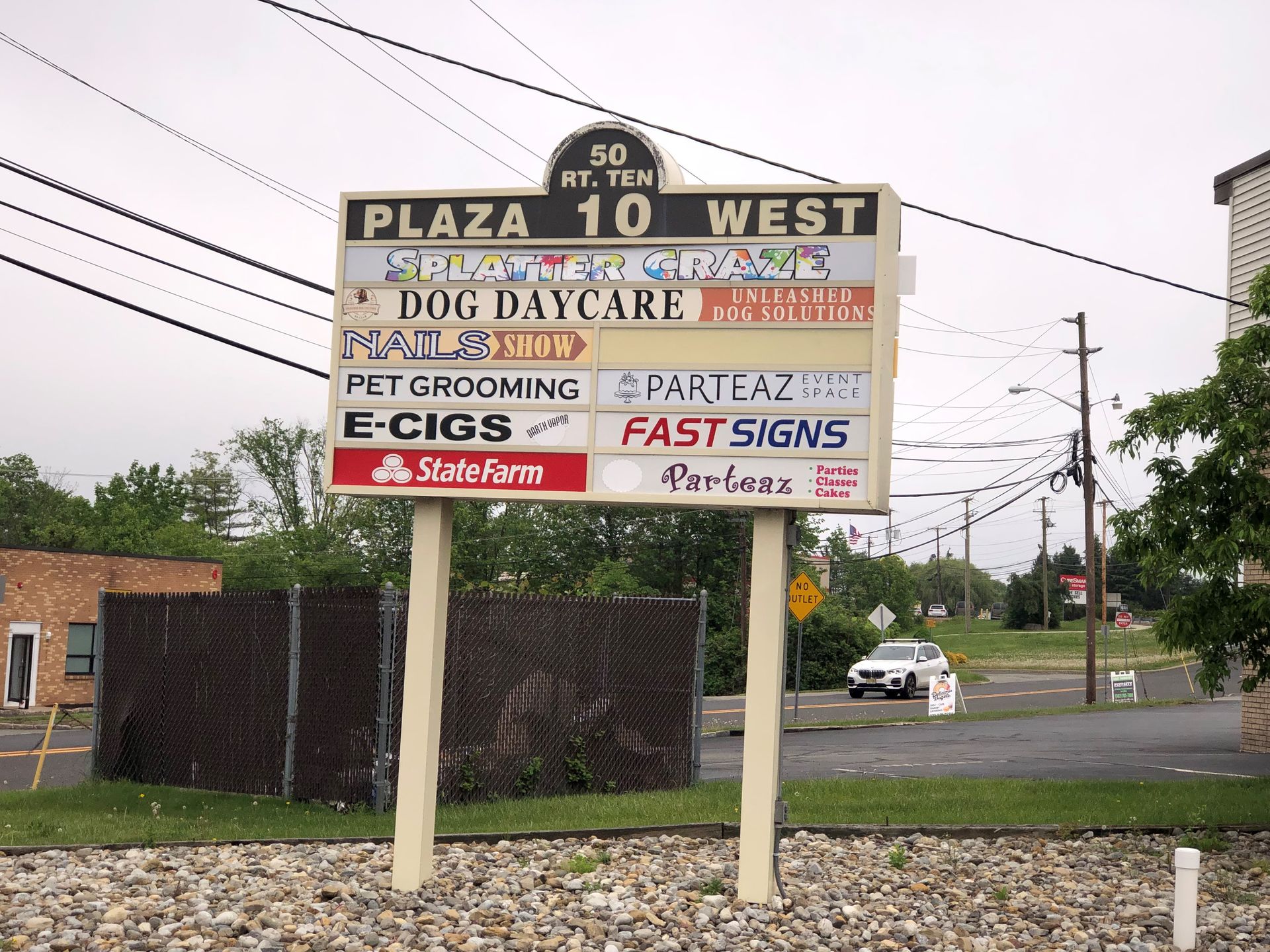 A sign for plaza 10 west has a lot of signs on it