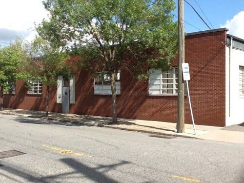 Trees On Side Of Brick Styled Warehouse — Clifton, NJ — Evergreen Commercial Real Estate Brokers Inc