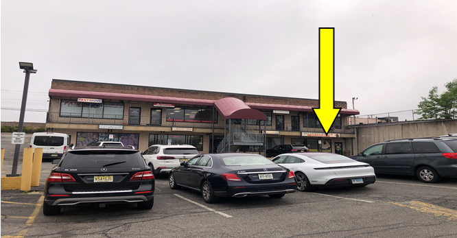 A parking lot with cars parked in front of a building.