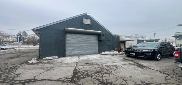 A gas station with a car parked in front of it.