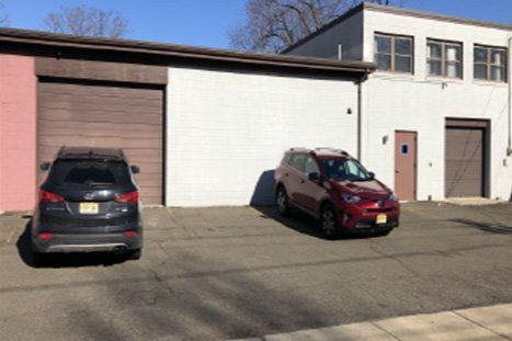 Two Cars Infront Of Warehouse — Clifton, NJ — Evergreen Commercial Real Estate Brokers Inc