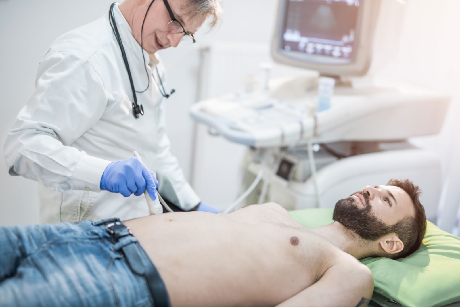 Un medico sta esaminando il torace di un uomo con un ecografo.