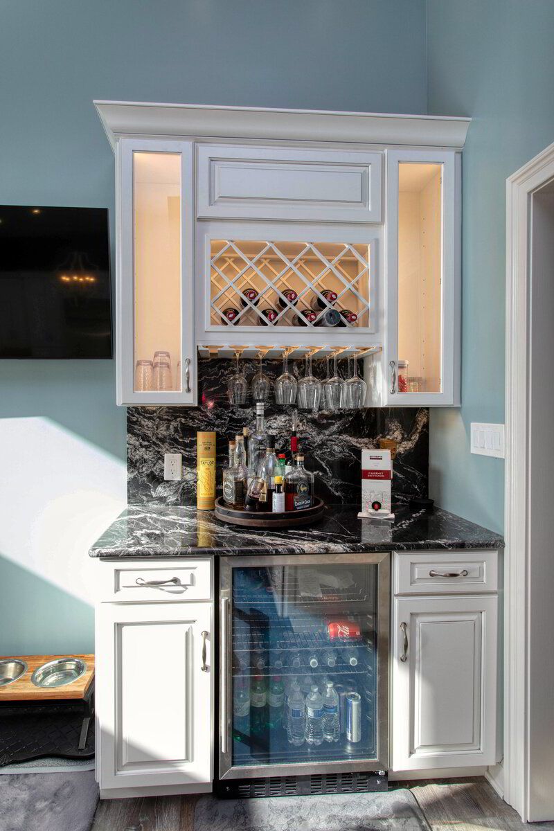 A kitchen with a wine rack and a refrigerator.