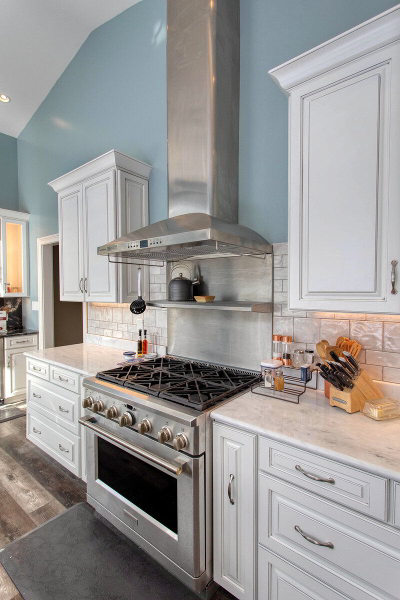 A kitchen with white cabinets and stainless steel appliances.