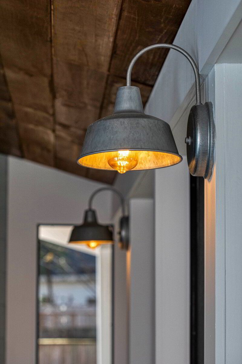 A couple of lights hanging on a wall next to a mirror.