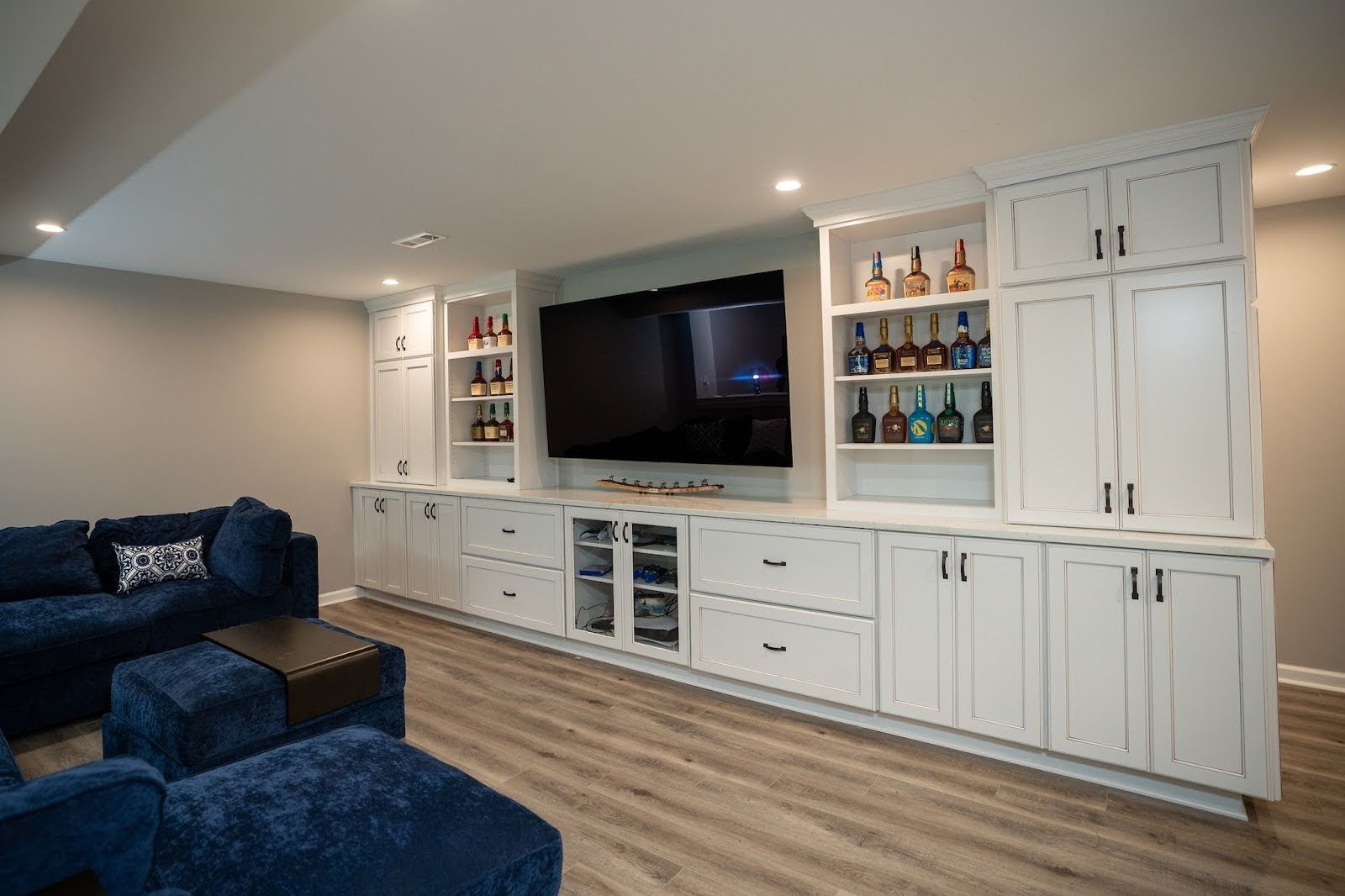 A living room with a couch , chairs , and a flat screen tv.