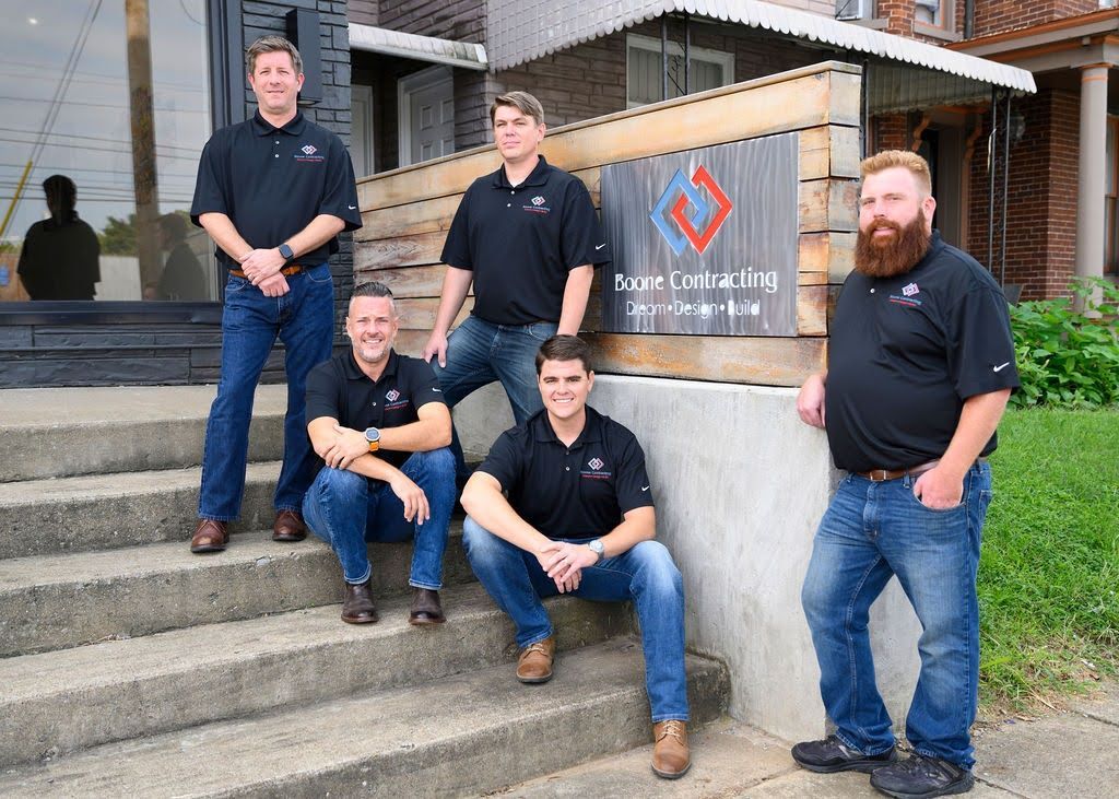 A group of men are posing for a picture in front of a building.