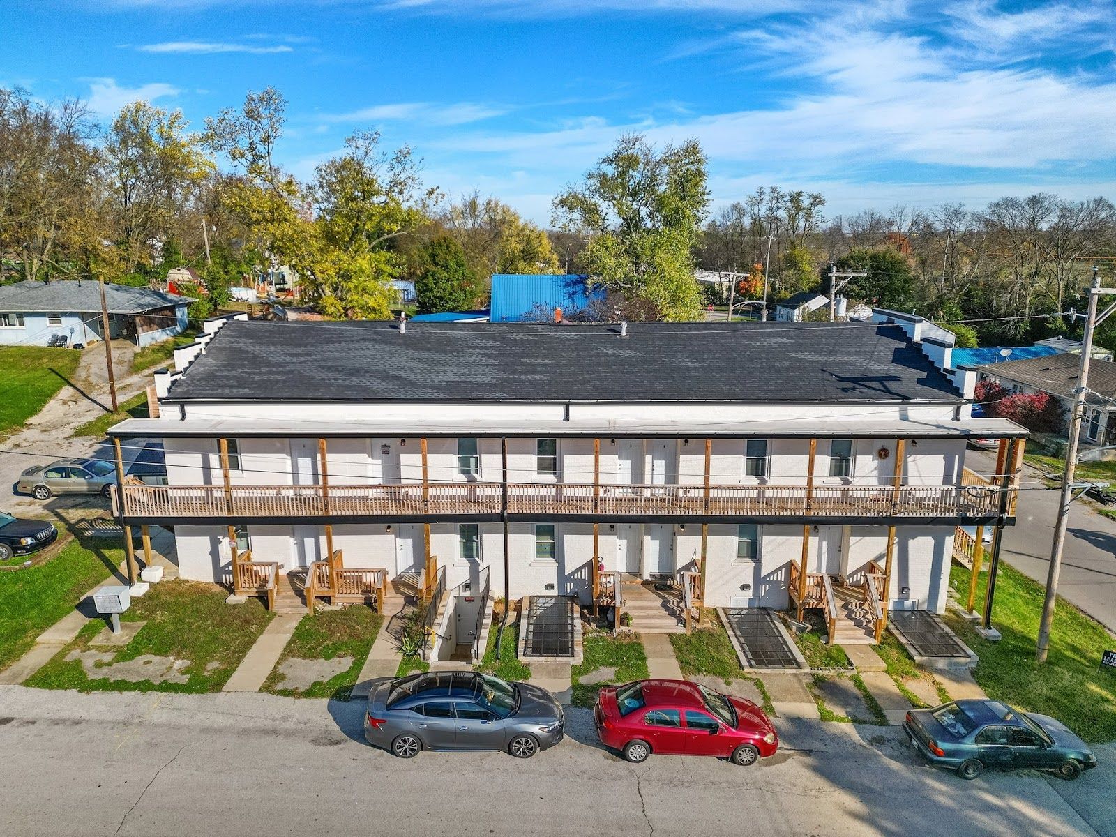 An aerial view of a apartment building with cars parked in front of it.