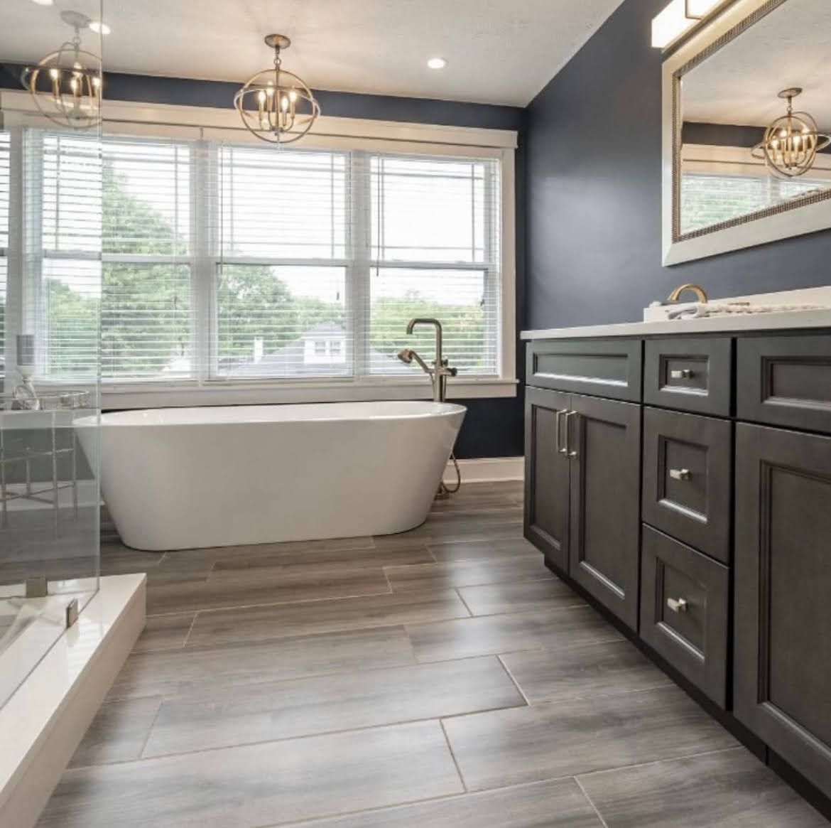 A bathroom with a tub , sink and mirror