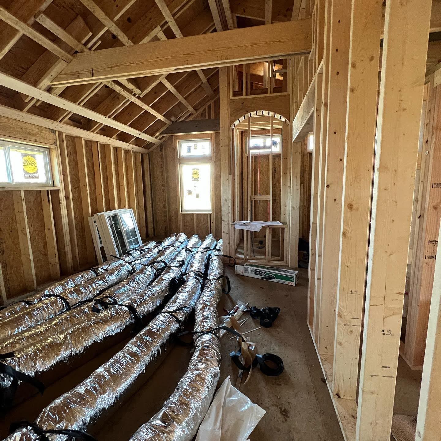 A room in a house under construction with a lot of ducts