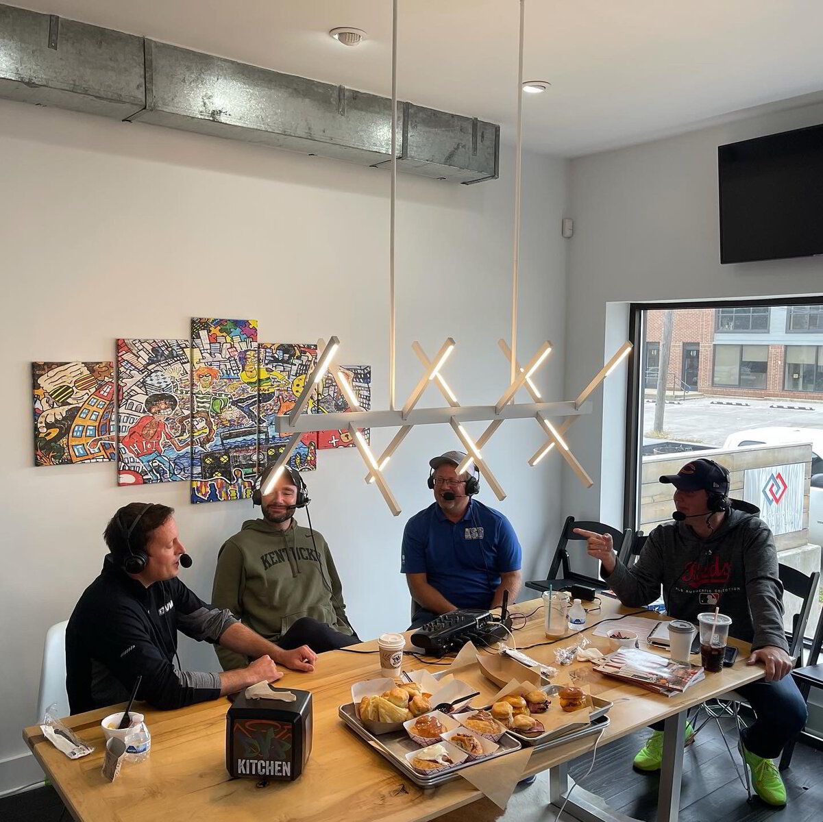 A group of men are sitting at a table eating pizza.