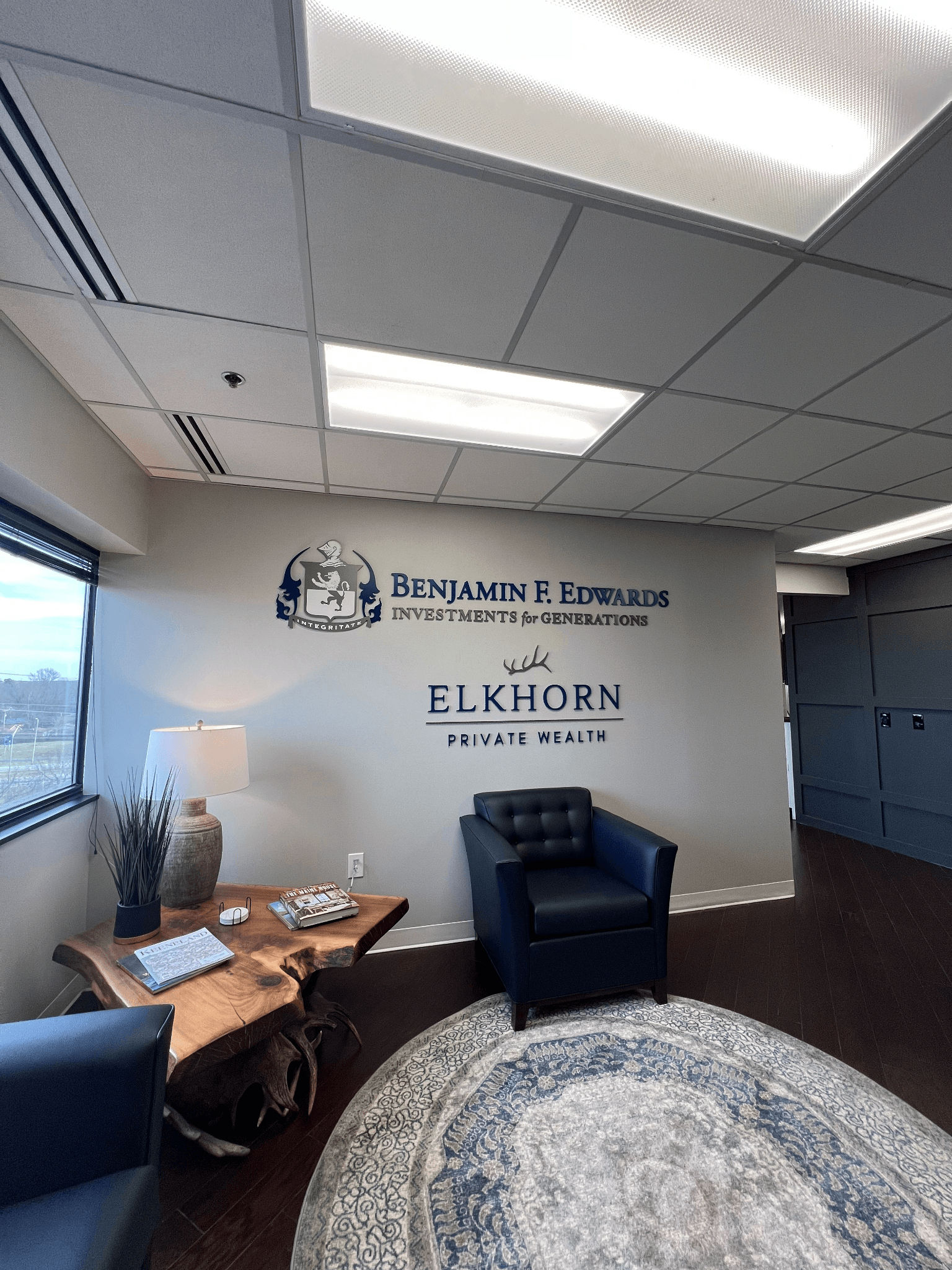 A living room with a chair , table , and window.
