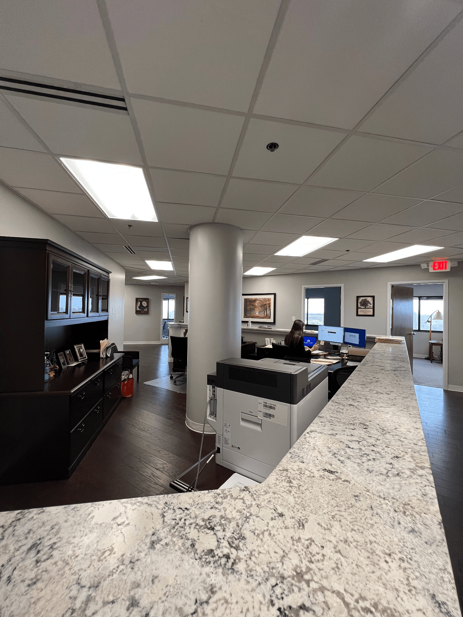 A man is sitting at a desk in a large office