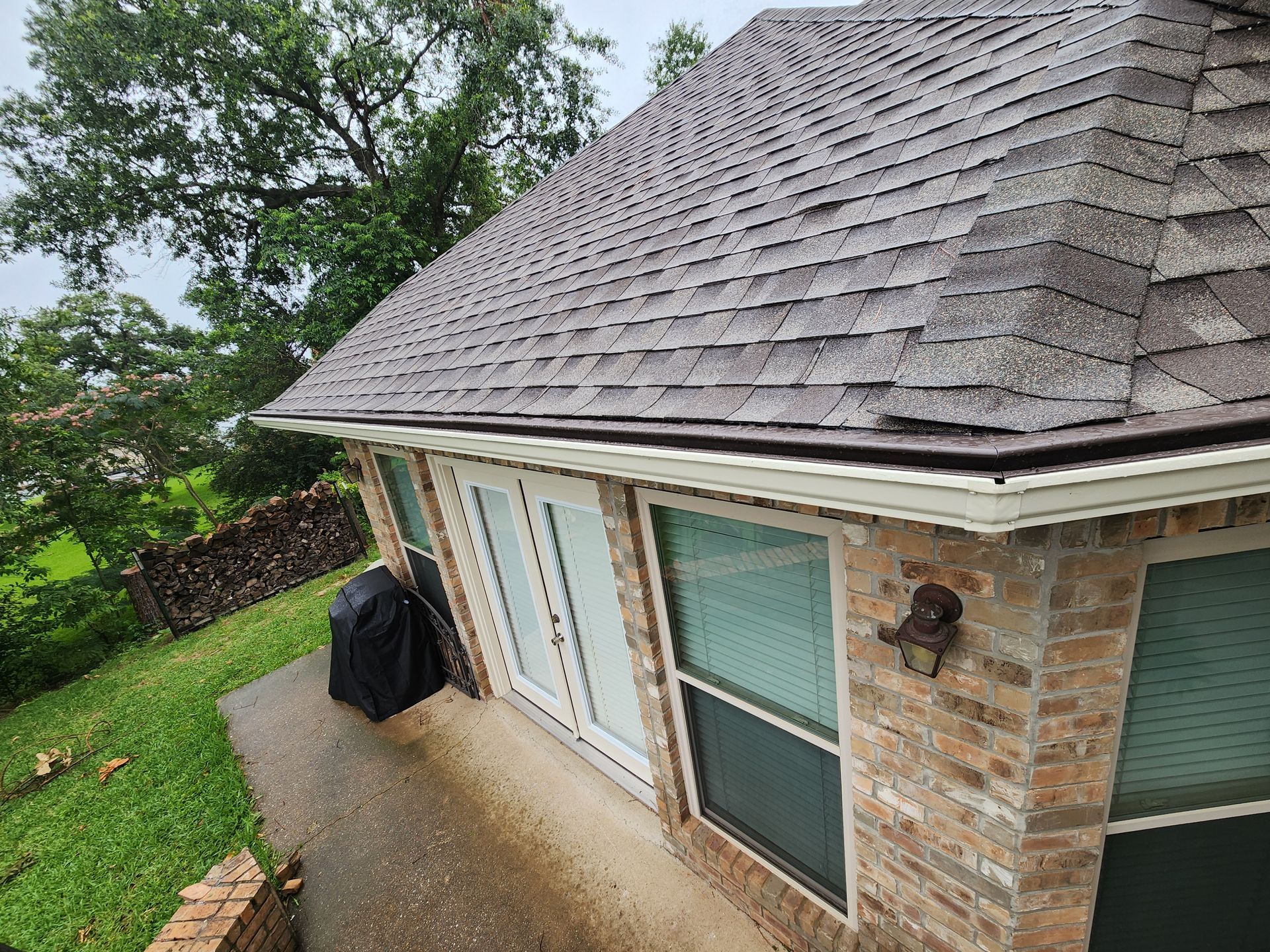 An aerial view of a brick house with a roof.
