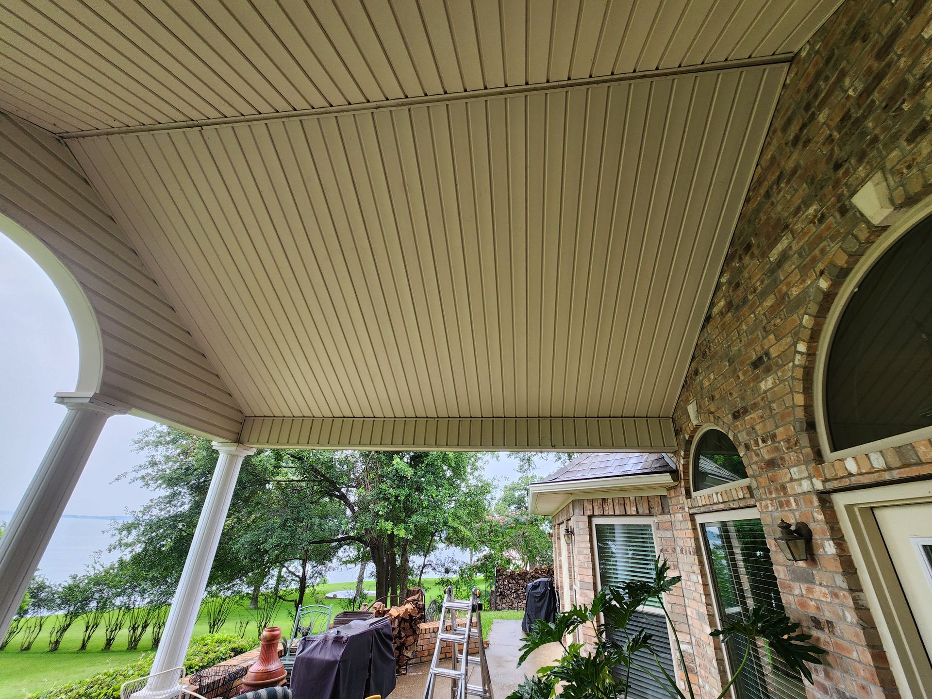A man is working on the roof of a porch.