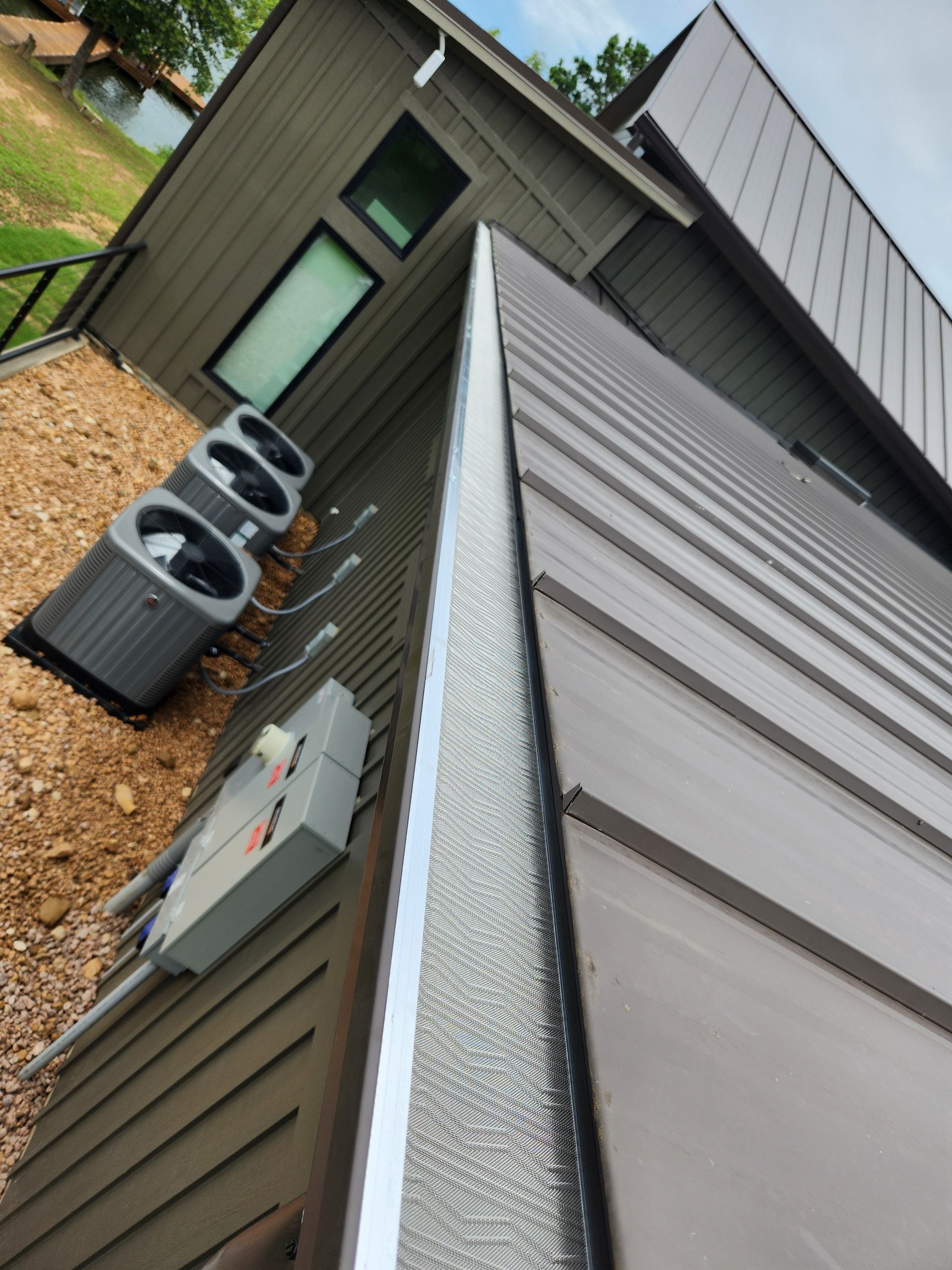 A house with a metal roof and air conditioners on the side