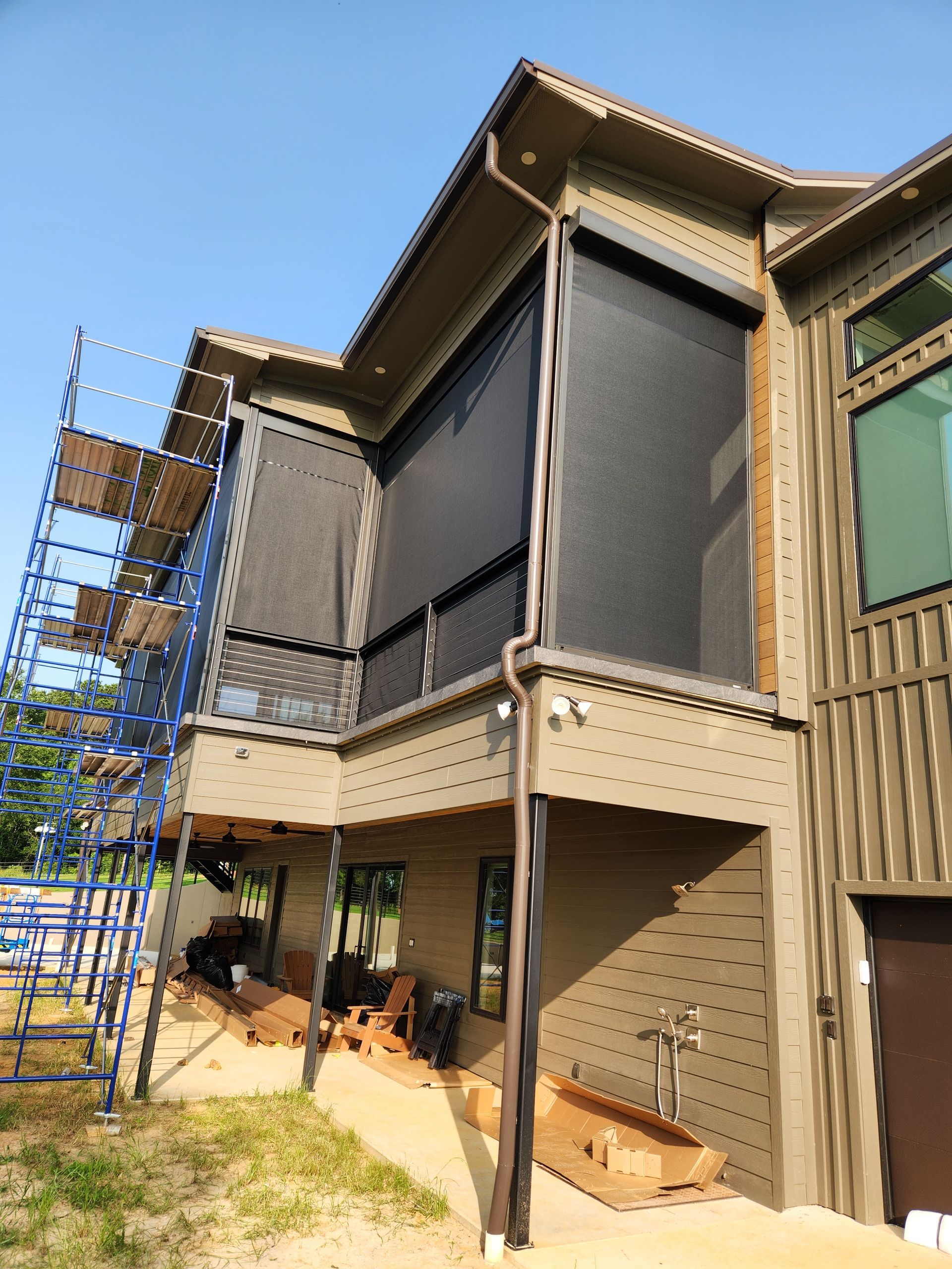 A large house with a screened in porch and scaffolding in front of it.