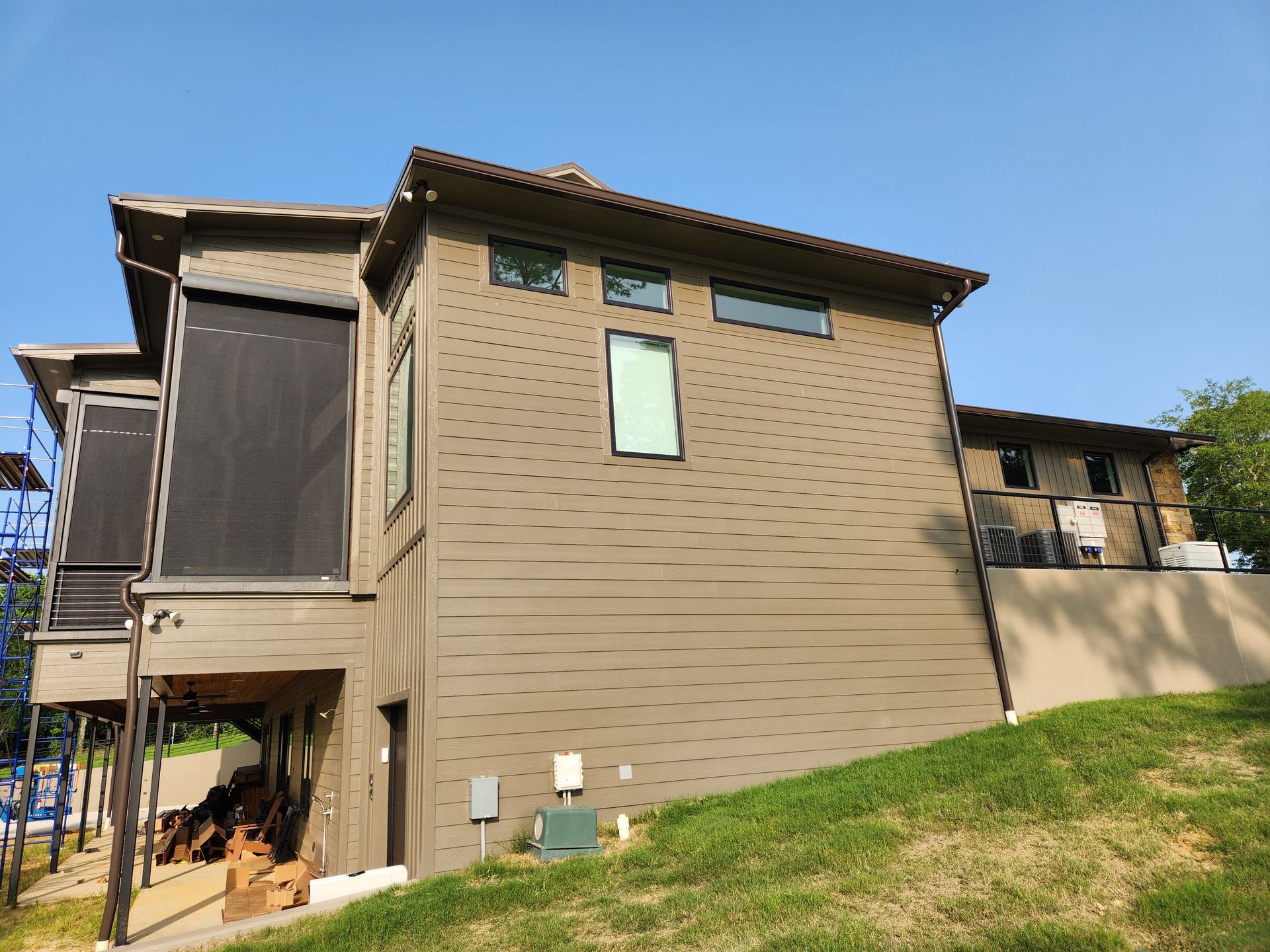 A large house is sitting on top of a grassy hill.