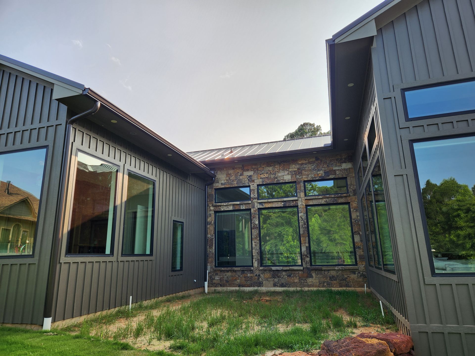 A large house with a lot of windows and a lot of grass in front of it.