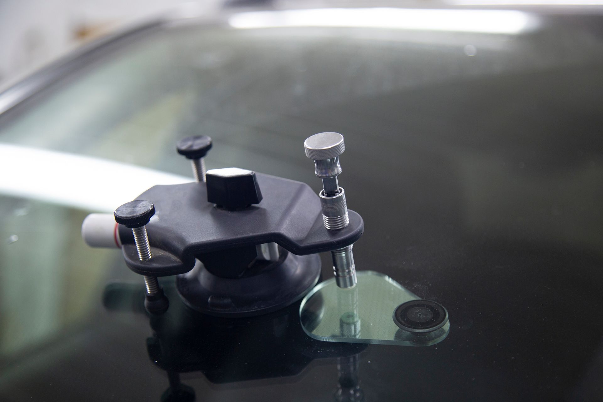 Windshield crack repair kit on a car, injecting resin to mend glass damage.