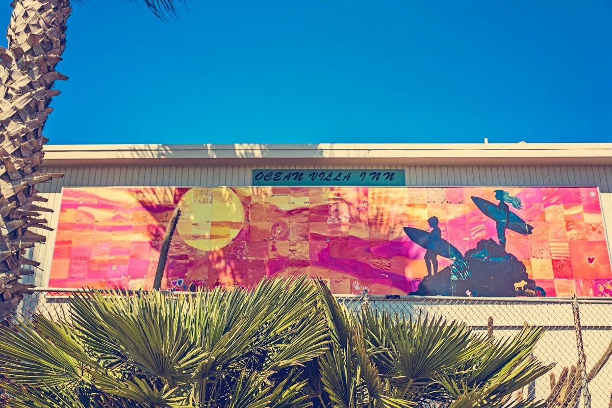 Colorful mural of surfers on a beach at 