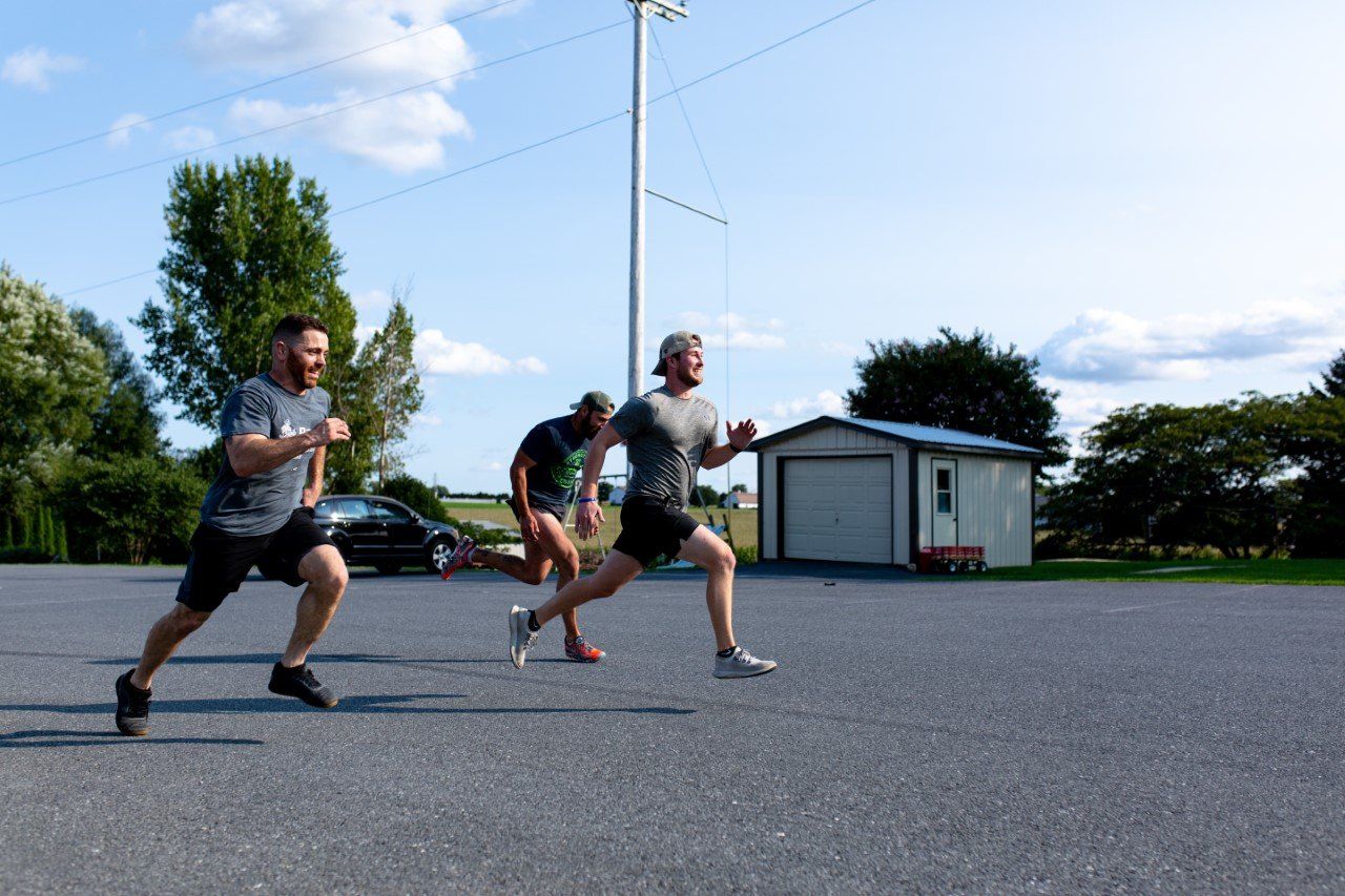 A group of people are running in a parking lot.