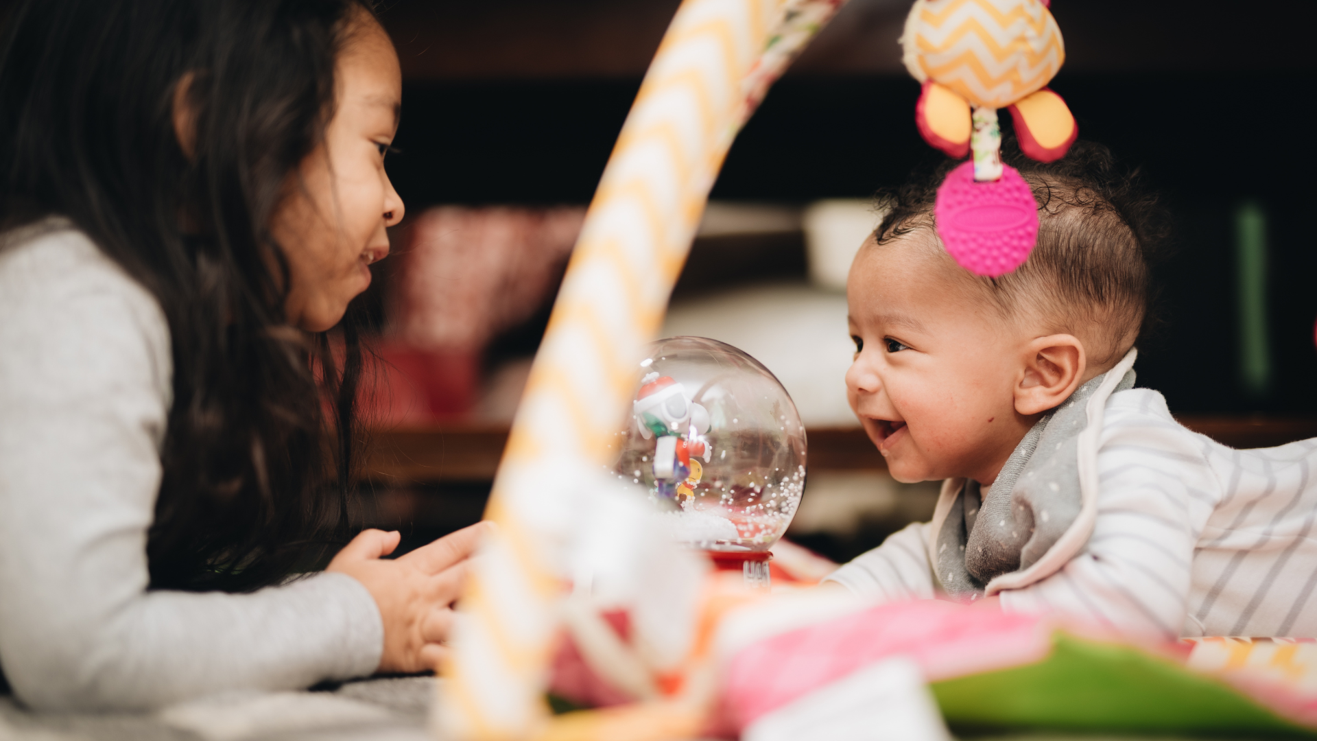 Empty, brightly lit preschool classroom with tables, toys, and shelving against white walls.