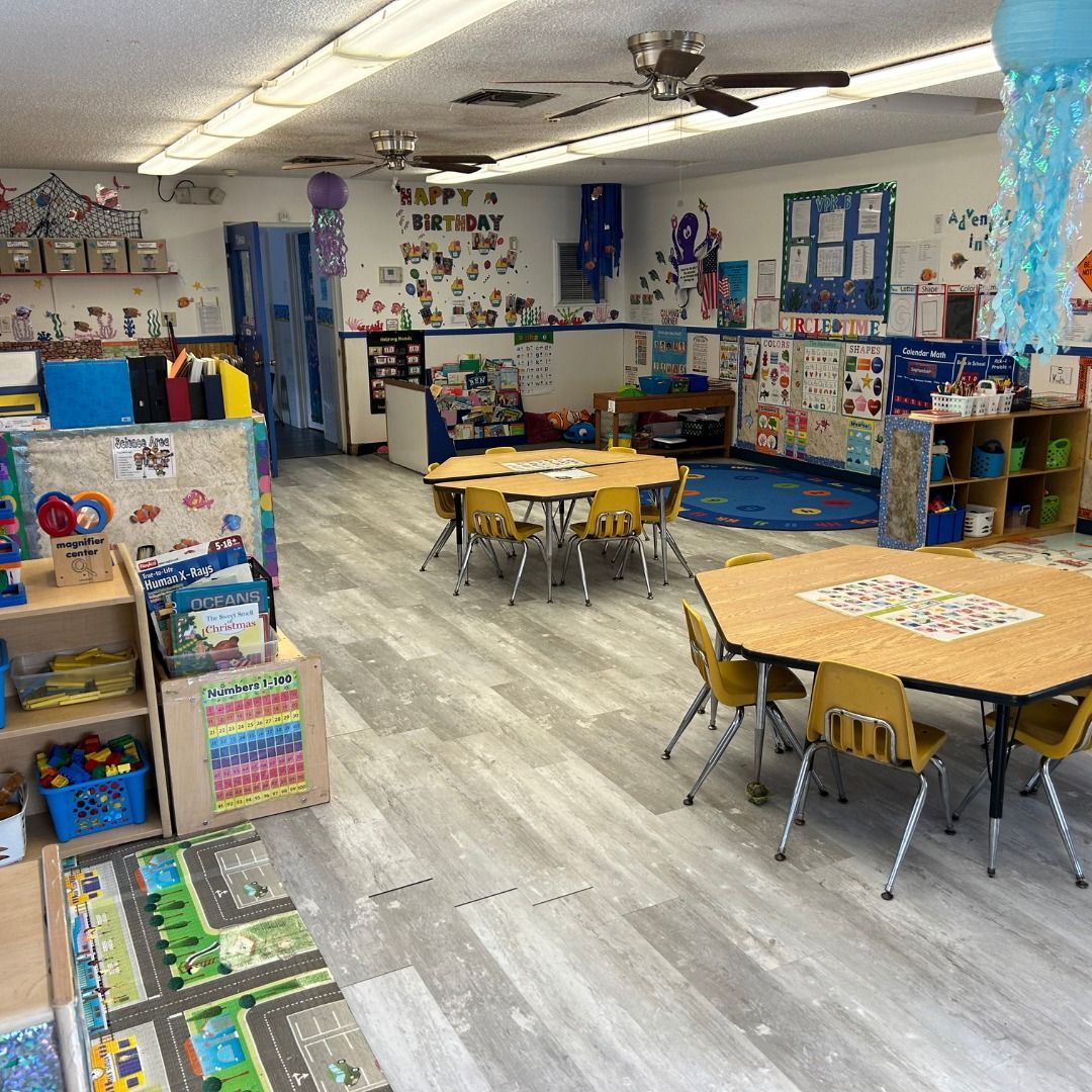 A classroom with tables and chairs and a lot of toys.