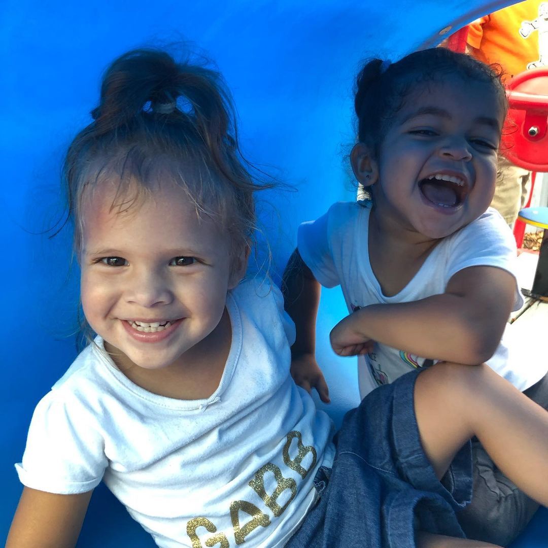 A little girl wearing a white shirt with the word care on it