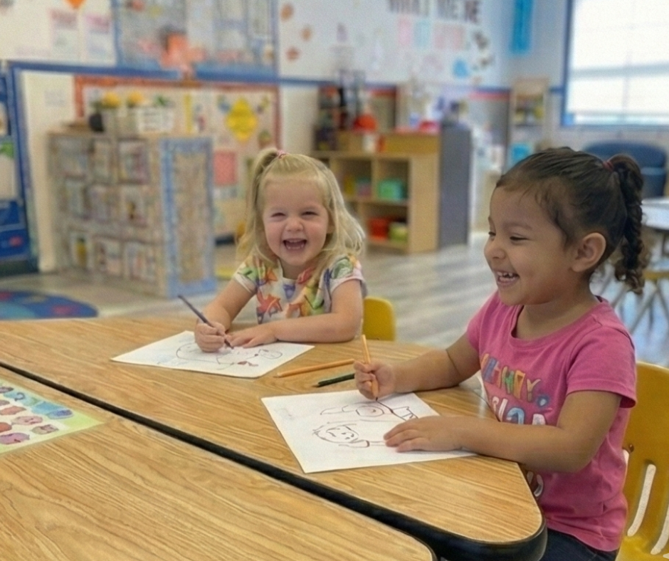 Teacher assisting children at a round table; children writing and playing with toys in a classroom.