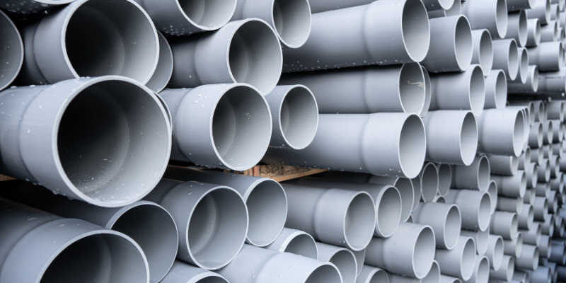 A stack of gray PVC pipes, arranged in a grid-like pattern.