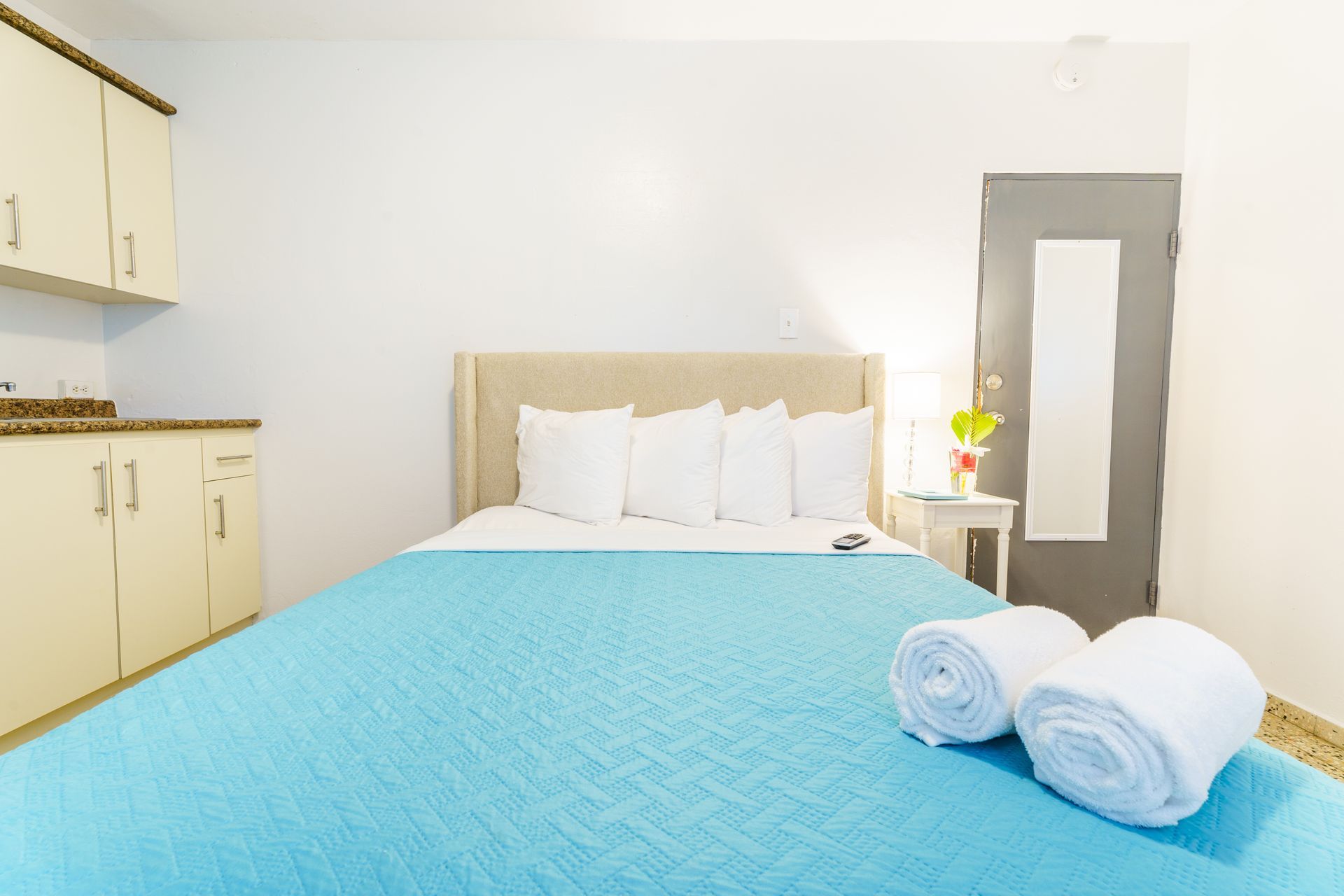 A hotel room with a bed and two towels on the bed.