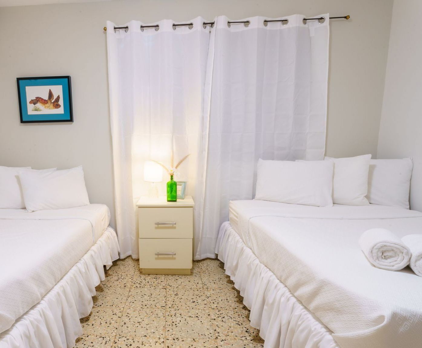 A hotel room with two beds and a nightstand