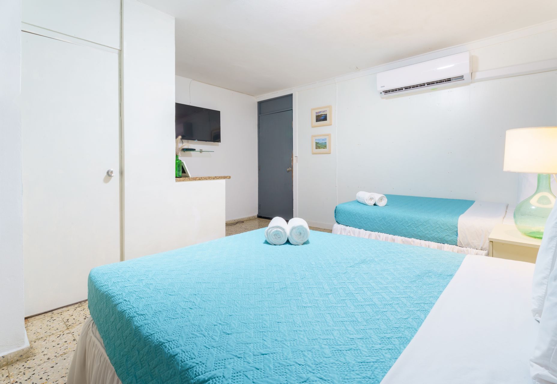 A hotel room with two beds and a television.