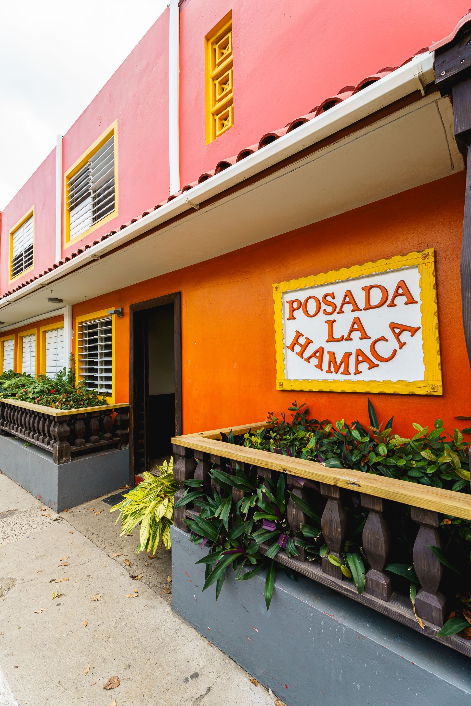 A red building with a sign that says posada la hamaca