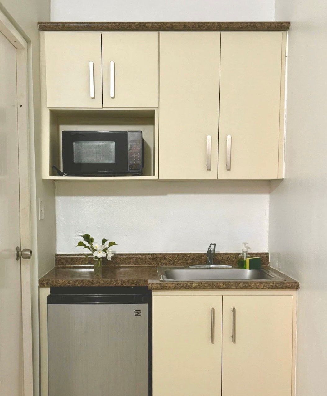 A small kitchen with a sink , microwave and dishwasher
