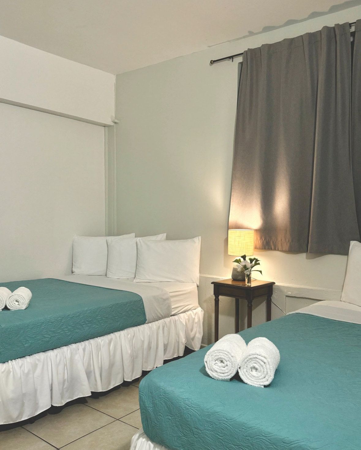 A hotel room with two beds and two towels on them