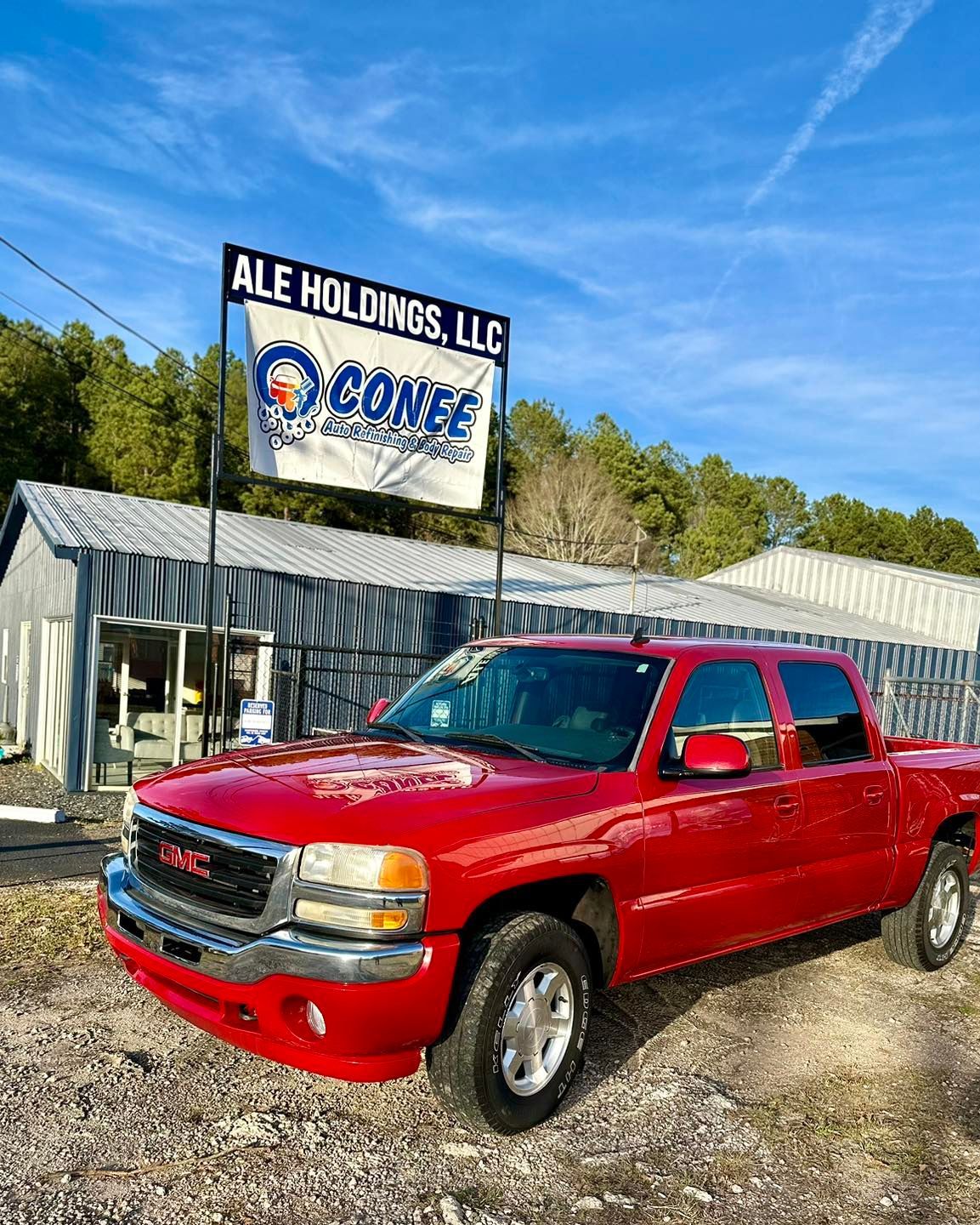 A red pickup truck is parked in front of a building.