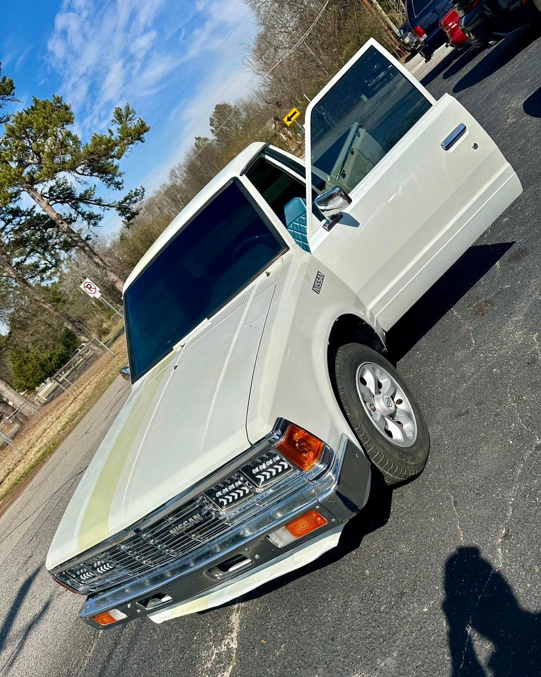 A white truck is parked on the side of the road with its doors open.