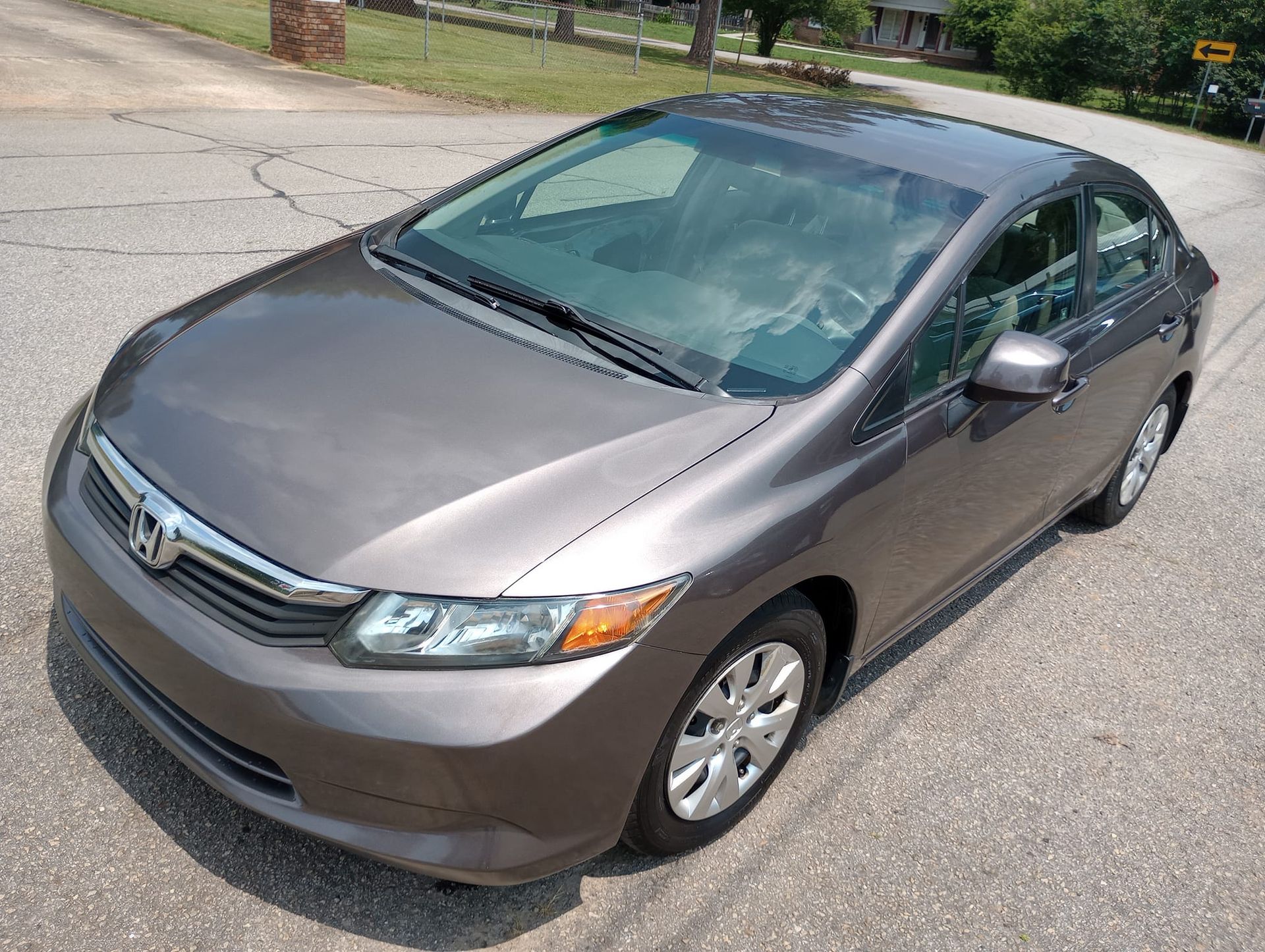 A gray honda civic is parked on the side of the road